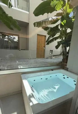 a jacuzzi tub in a room with a palm tree at Τhe Noverian Antama Organic Beach Resort Chania with Outdoor Heated Pool in Agia Marina Nea Kydonias