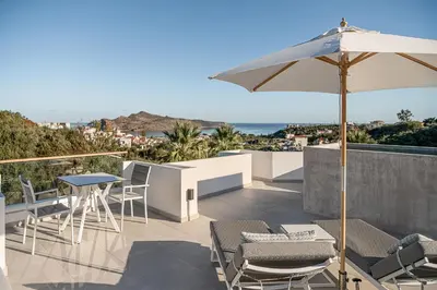 a patio with a table and chairs and an umbrella at Villa Life in Agia Marina Nea Kydonias