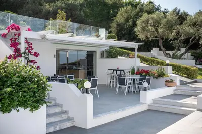 a white villa with a patio with a table and chairs at Villa Life in Agia Marina Nea Kydonias