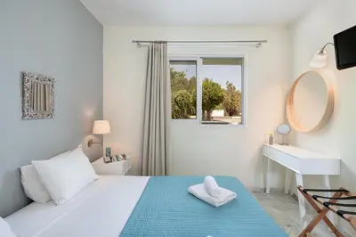 a white bedroom with a bed and a sink and a mirror at Villa Life in Agia Marina Nea Kydonias