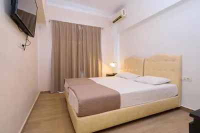 a bedroom with a large bed and a television at Archontiki City Hotel in Chania Town