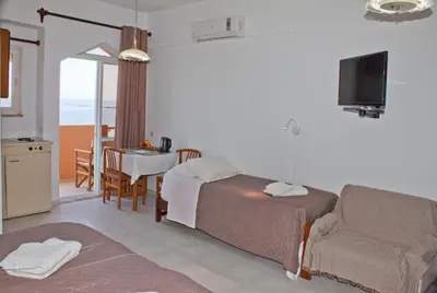 a hotel room with a bed and a couch and a table at Melani Apartments in Chania Town
