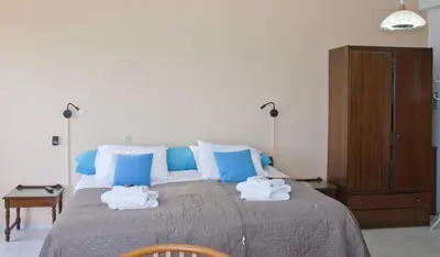 a bedroom with a large bed with blue and white pillows at Melani Apartments in Chania Town
