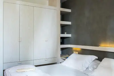 a bedroom with a bed and a white cabinet at Elea Villas - Aspro & Blanche in Almirida