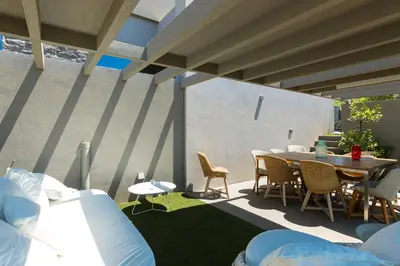 a patio with a table and chairs and a table and a table and chairs at Elea Villas - Aspro & Blanche in Almirida