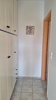 a kitchen with white cabinets and a tile floor at Kalliopi Studios - Apartments in Kato Daratso