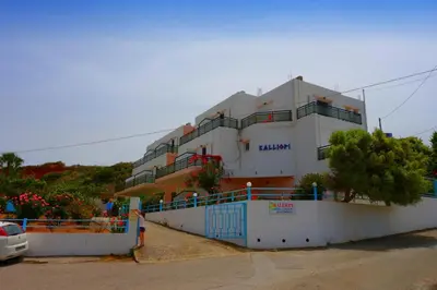 a large white building with a fence in front of it at Kalliopi Studios - Apartments in Kato Daratso