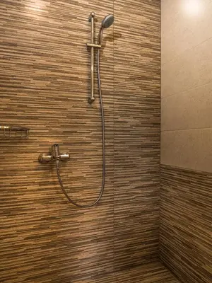 a shower with a hose on a wall in a bathroom at Villa Alexander in Kalathas
