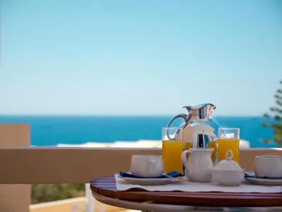 a table with a coffee maker and glasses of orange juice at Villa Alexander in Kalathas