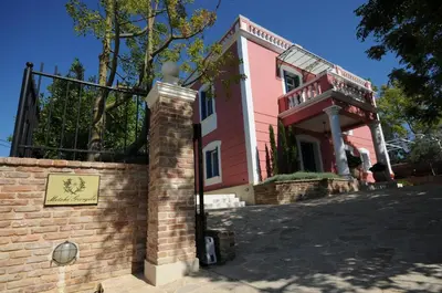 a red and white building with a brick wall at Metohi Georgila in Maleme