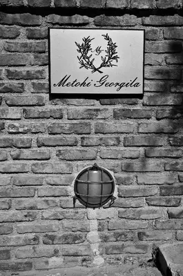 a sign on the side of a brick wall at Metohi Georgila in Maleme
