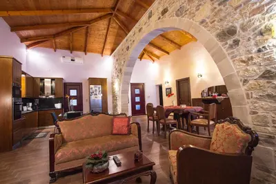 a living room with a couch and a stone wall at PRIVATE Sapphiros Villa in Kissamos