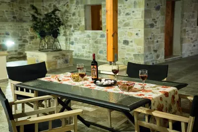 a table with a bottle of wine and glasses on it at PRIVATE Sapphiros Villa in Kissamos
