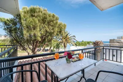 a table with wine glasses and flowers on a balcony at Maria's Studios in Frangokastello