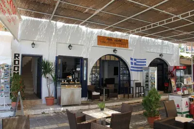 a restaurant with tables and chairs in front of a building at Hotel Alkyon in Khóra Sfakíon