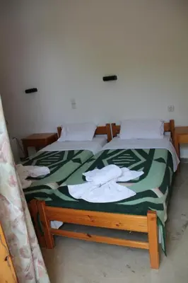 two beds in a room with towels on them at Hotel Alkyon in Khóra Sfakíon