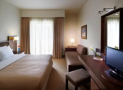 a hotel room with a bed and a couch and a television at Irida Hotel in Chania Town
