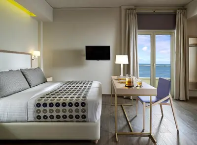 a bedroom with a bed and a desk and a table with a desk at Irida Hotel in Chania Town