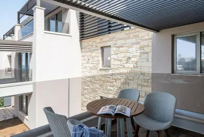 a patio with a table and chairs and a building at Cretan Dream Resort & Spa in Stalos