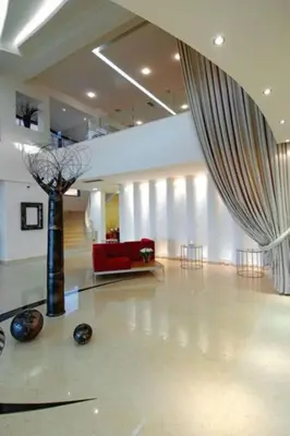 a living room with a red couch and a curtain at Cretan Dream Resort & Spa in Stalos