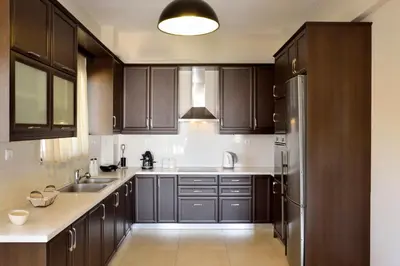 a kitchen with wooden cabinets and a stainless steel refrigerator at Elia Kounoupidiana Apartment in Kounoupidhianá