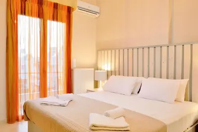 a bedroom with a large white bed with towels on it at Elia Kounoupidiana Apartment in Kounoupidhianá