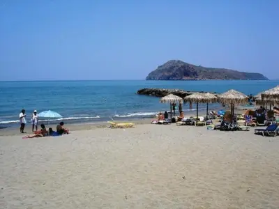 a group of people sitting on a beach with umbrellas at Margarita Beach Hotel in Agia Marina Nea Kydonias