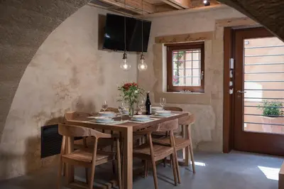 a dining room with a wooden table and chairs at Neoria Houses in Chania Town