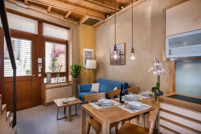 a living room with a table and a blue couch at Neoria Houses in Chania Town