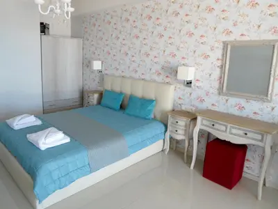 a small bedroom with a bed and a mirror at Petrakis sunset in Palaiochóra