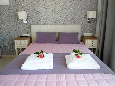 a bedroom with a pink bed with towels on it at Petrakis sunset in Palaiochóra