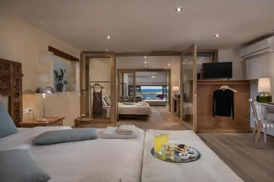 a bedroom with a large white bed with a tray of food at Residenza Vranas Boutique Hotel in Chania Town