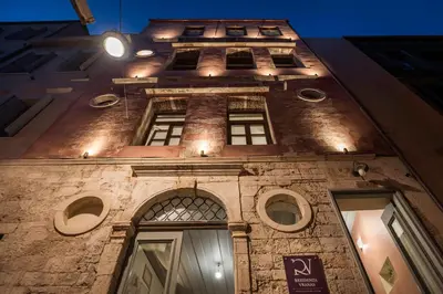 a tall brick building with windows at night at Residenza Vranas Boutique Hotel in Chania Town