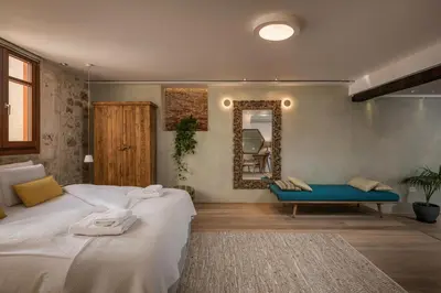 a bedroom with a large bed and a mirror at Residenza Vranas Boutique Hotel in Chania Town