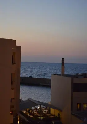 a view of the ocean at sunset from a building at Casa Sabbionara in Chania Town