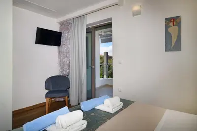 a bedroom with a bed and a chair and a window at Sunlight Breeze Villa in Chania Town