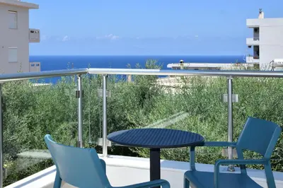 a balcony with a table and chairs and the ocean at Sunlight Breeze Villa in Chania Town