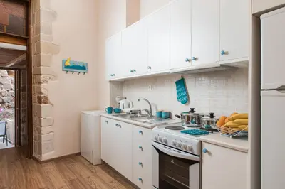 a kitchen with white cabinets and a stove top oven at Aeria Apartments in Chania Town