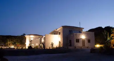 a large building with lights in the night at Anny's Homes in Kountoura Selino