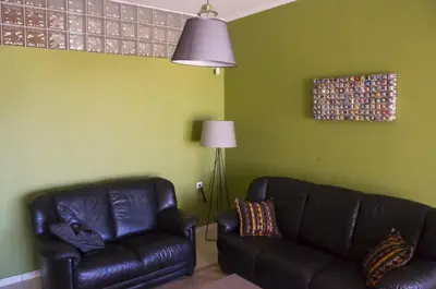 a living room with a black leather couch and a lamp at Horizon Villa Kampani in Kambánion