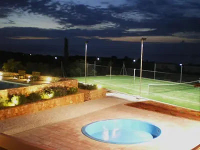 a tennis court with a large blue tub on a patio at Horizon Villa Kampani in Kambánion