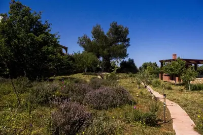 a garden with flowers and trees and a house at Horizon Villa Kampani in Kambánion