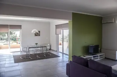 a living room with a couch and a table with a tv at Horizon Villa Kampani in Kambánion
