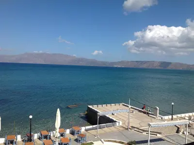 a view of a large body of water with tables and chairs at Argo Rooms-Papadakis in Kissamos