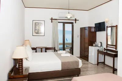 a bedroom with a bed and a desk and a television at Argo Rooms-Papadakis in Kissamos
