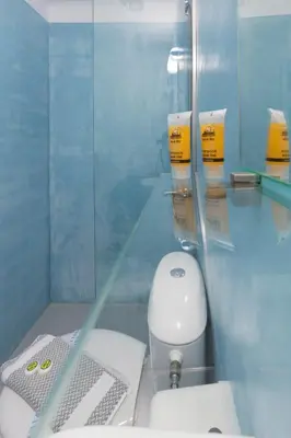 a bathroom with a white toilet and a glass wall at Kissamia - Self Check In Only - Next to Night Clubs in Kissamos