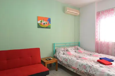 a bedroom with a bed and a red chair at Economy Studio Apartments in Chania Town