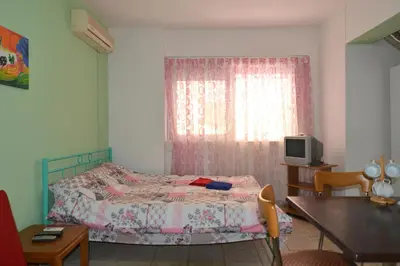 a bedroom with a bed and a table and a television at Economy Studio Apartments in Chania Town