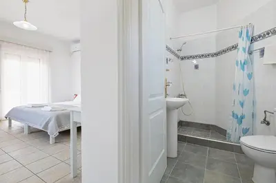 a white bathroom with a sink and a toilet at Marias Studios & Apartments in Platanias in Plataniás