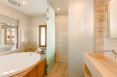 a bathroom with a large white tub and a sink at Querini Luxury Suites in Chania Town
